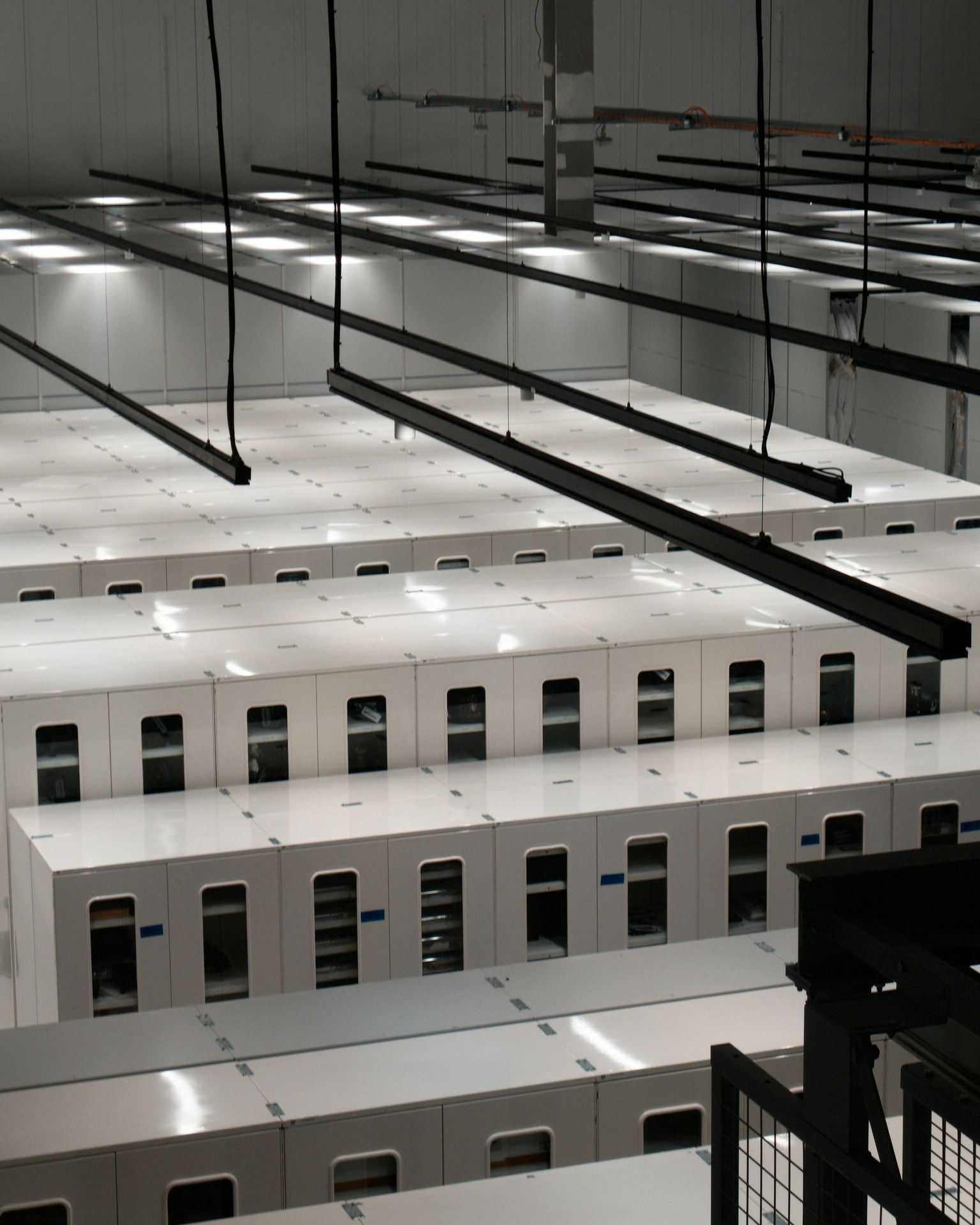 Rows of white equipment cabinets seen from above