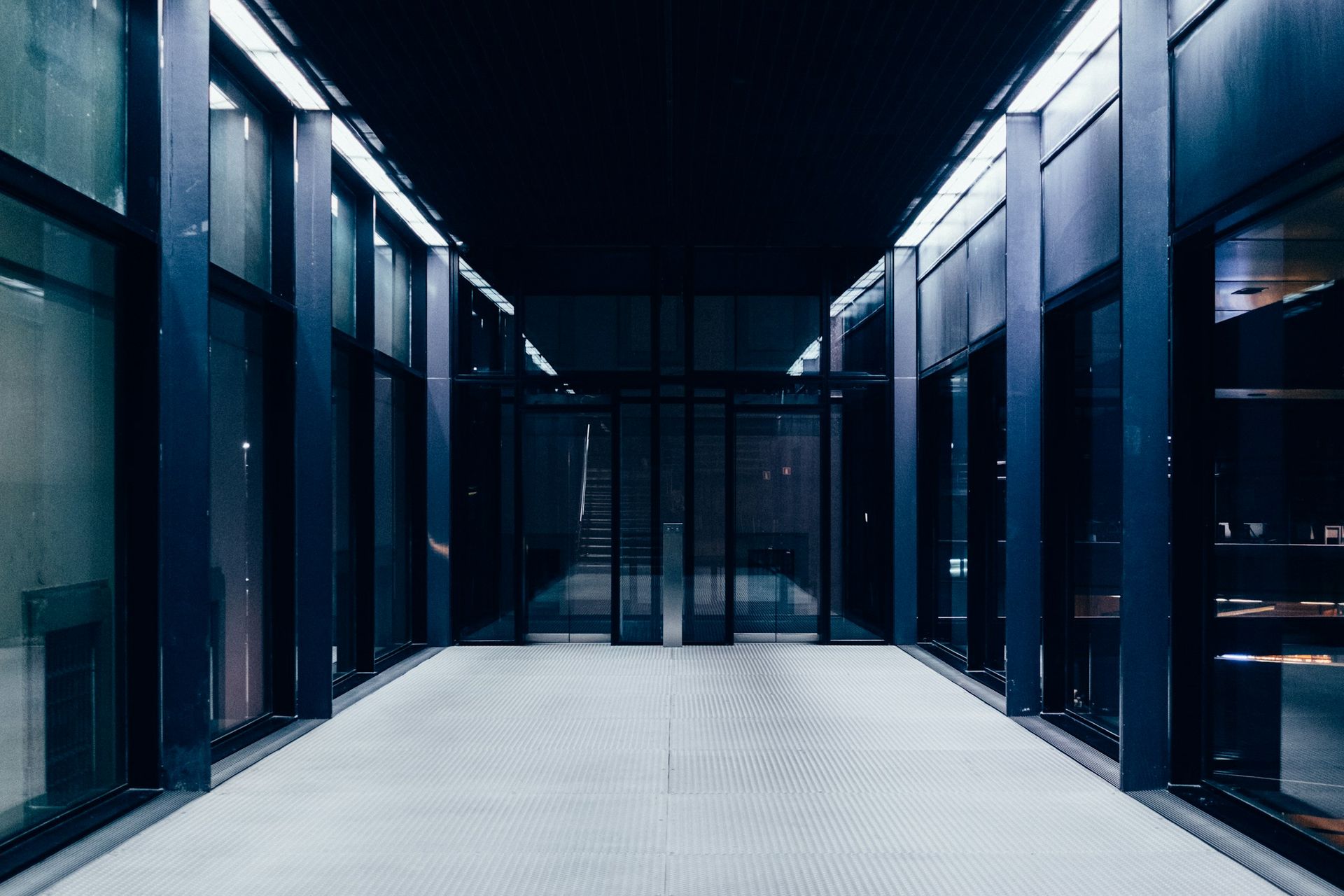 Long, dark corridor lined with glass panels